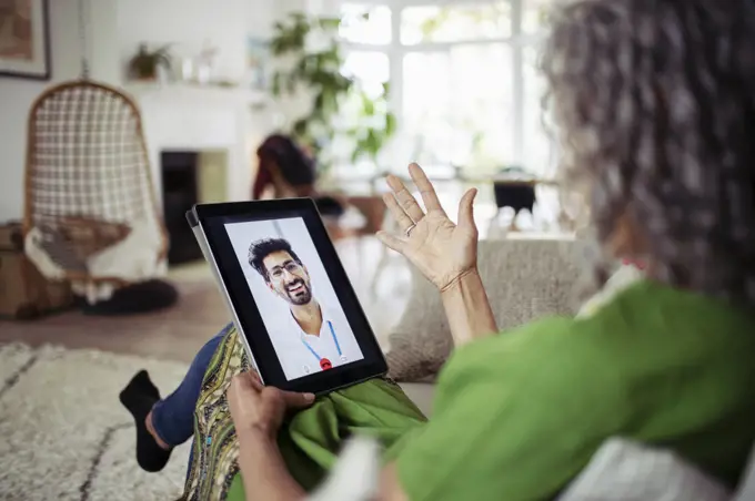 Woman video chatting with doctor on digital tablet screen