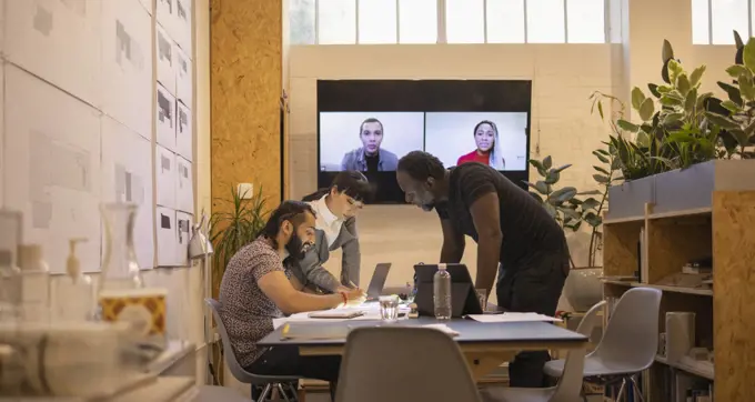 Architects video conferencing in office meeting