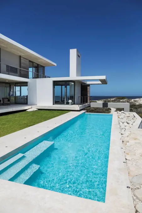 Lap pool and lawn outside modern house