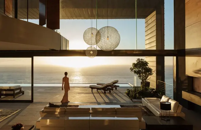 Woman in modern house overlooking ocean, Cape Town, South Africa