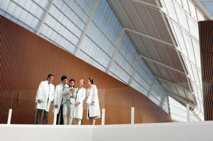 Spain, Doctors and businesswoman using digital tablet on modern balcony