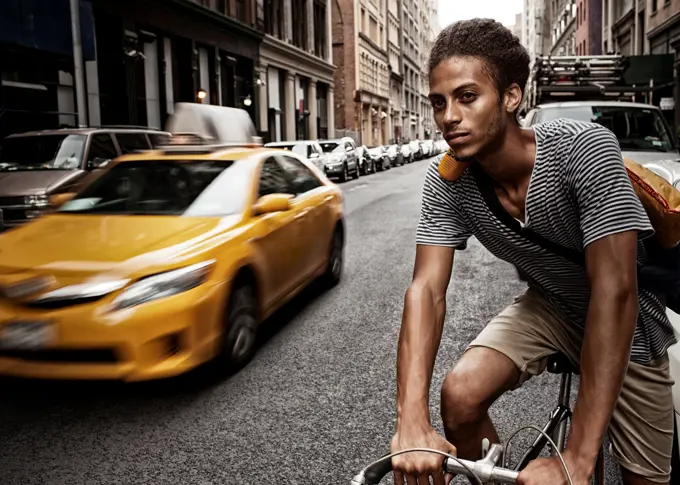 Man riding bicycle on city street,New York