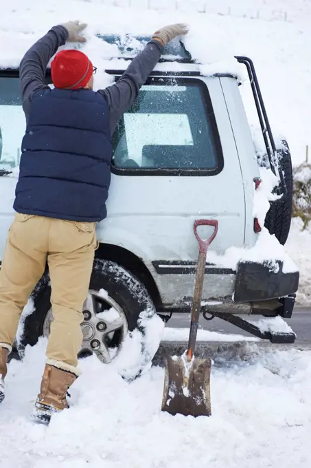 Man digging car out of snow