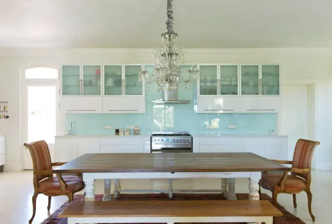 Chandelier over wooden table in kitchen