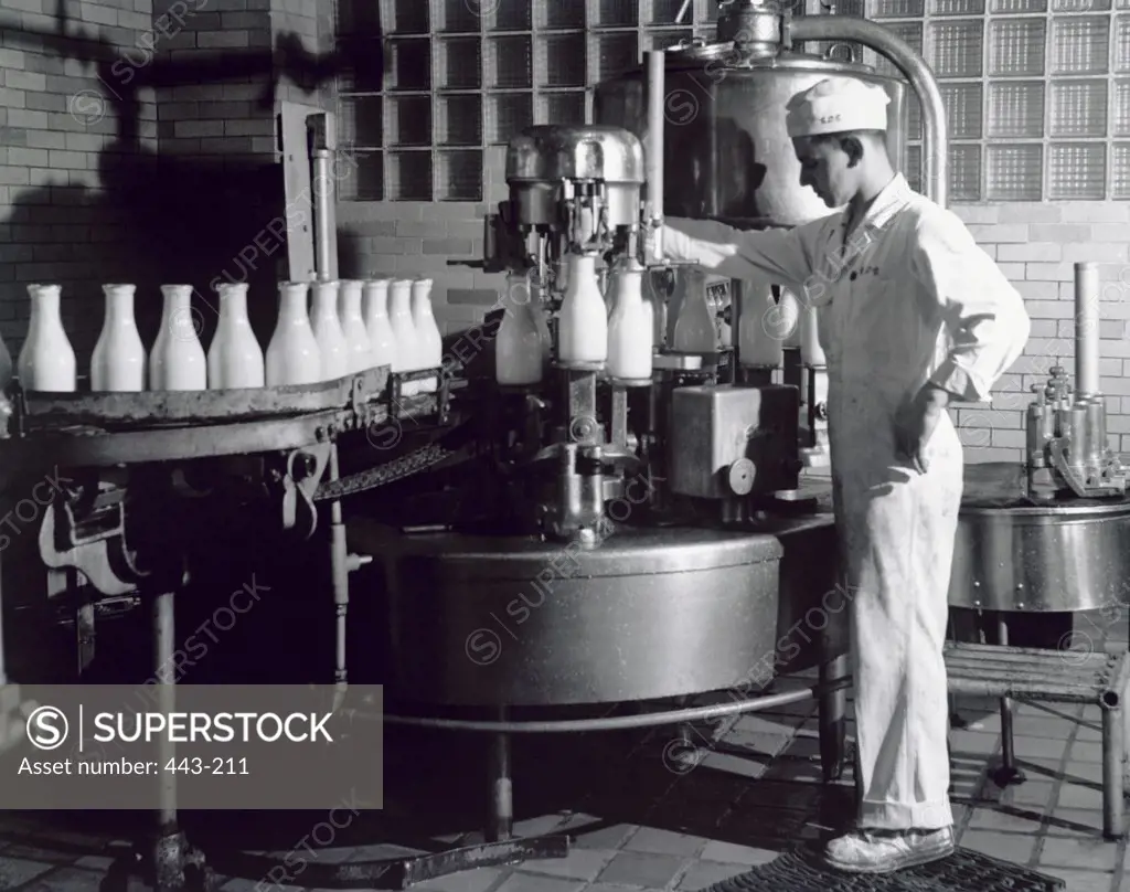 Side profile of a young man working in a milk bottling plant, 1942