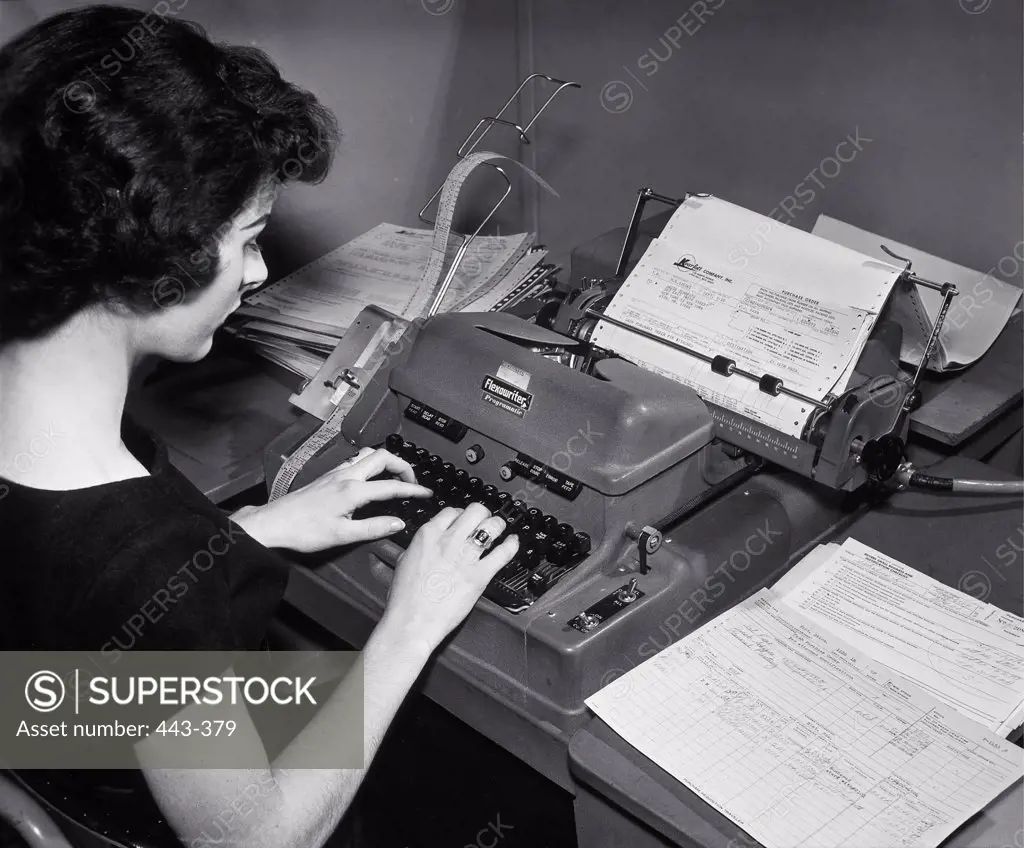 High angle view of a businesswoman typing, 1960