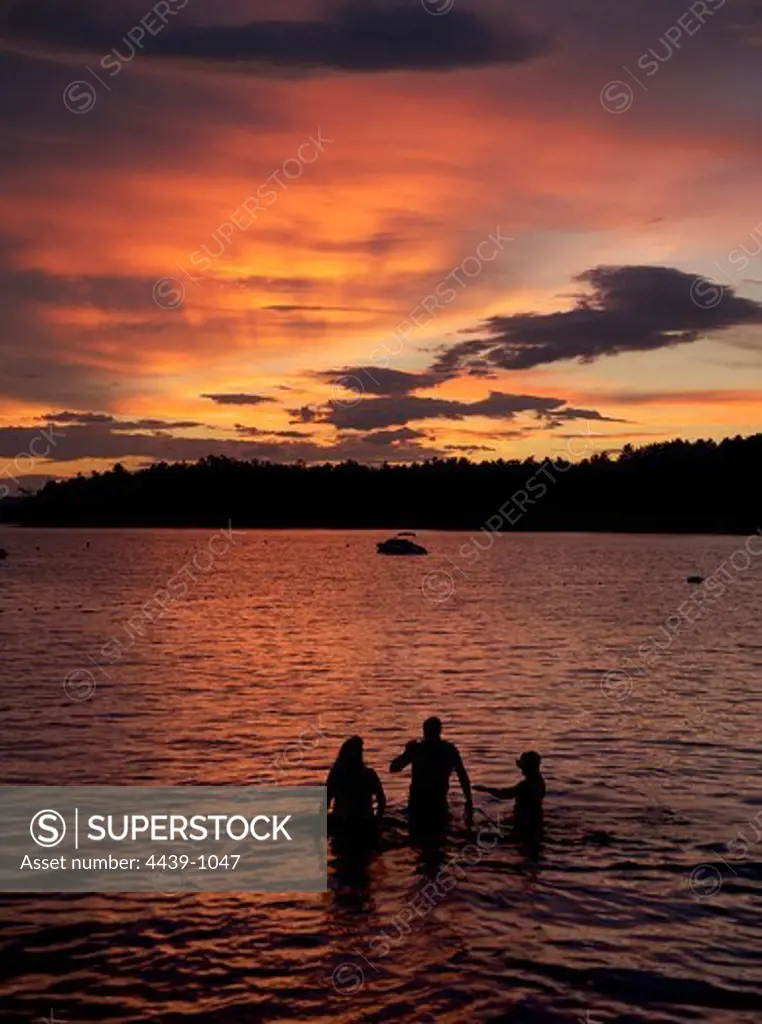 Silhouette of a family in a lake, Lake Winnipesaukee, New Hampshire, USA