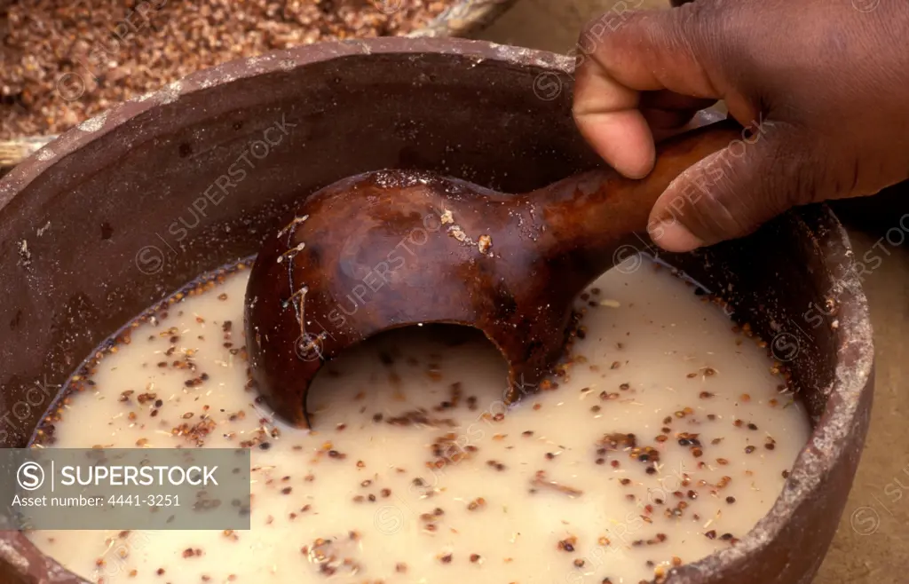 Zulu beer making. Scooping sorgum mixture into a calabash. Shakaland, Eshowe. KwaZulu-Natal. South Africa.