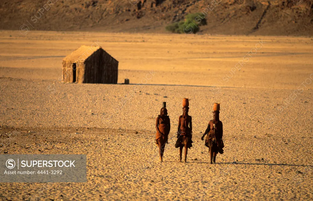 Himba Women. Walking in desert. Near Purros. Namibia.