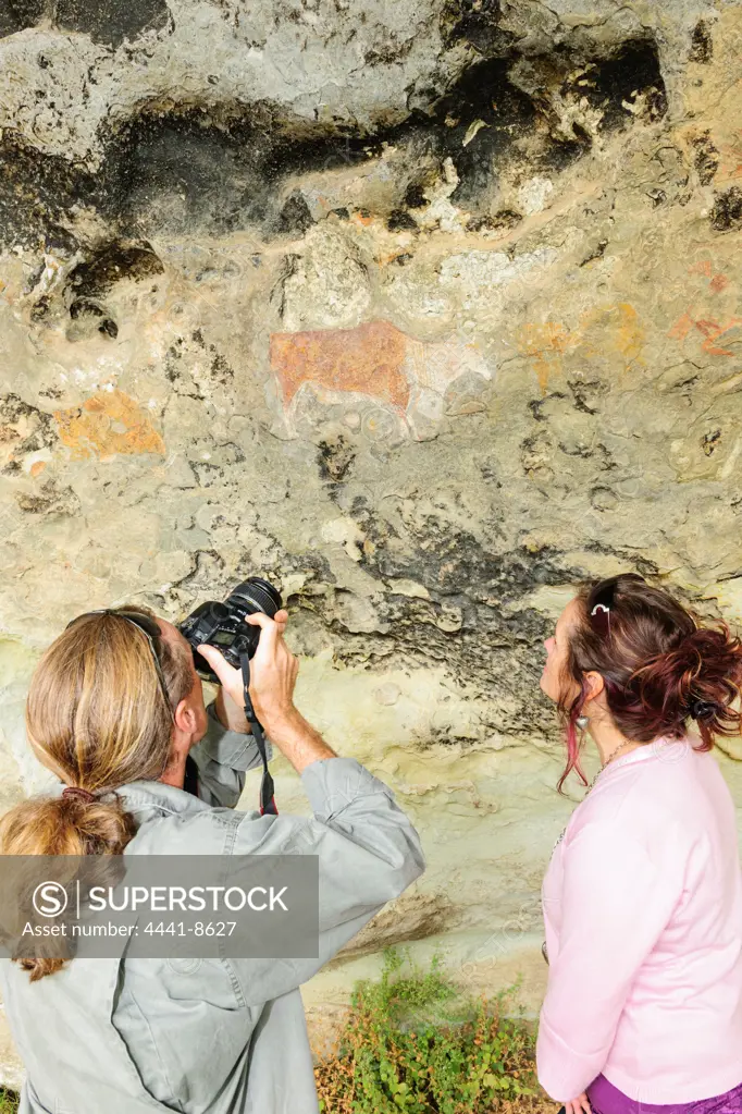 Tourists looking at San or Bushman rock art near Clarens. Free State. South Africa