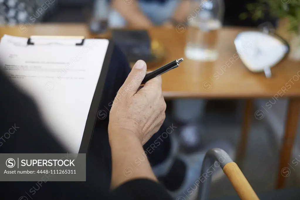 Cropped image of male therapist with reports on clipboard at community center