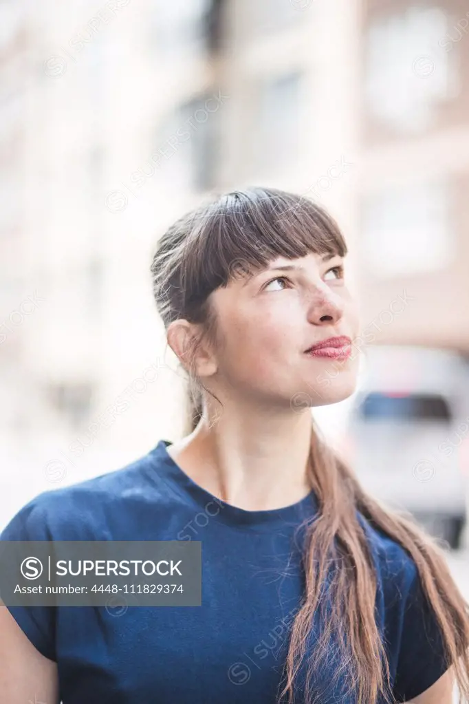 Smiling young woman looking up