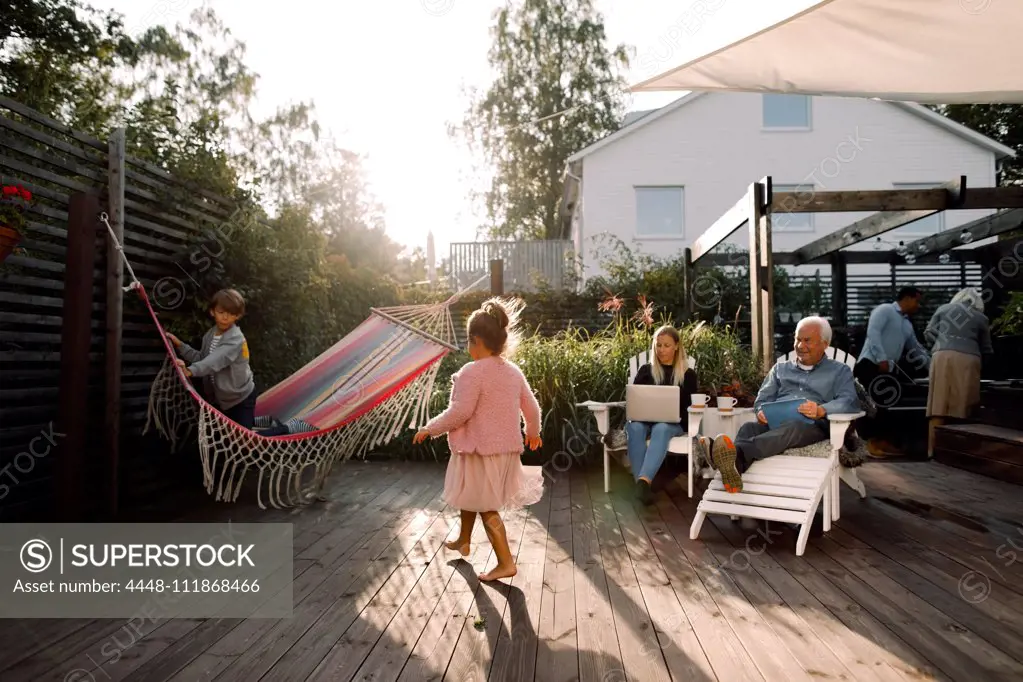 Multi-generation family spending leisure time in backyard during weekend