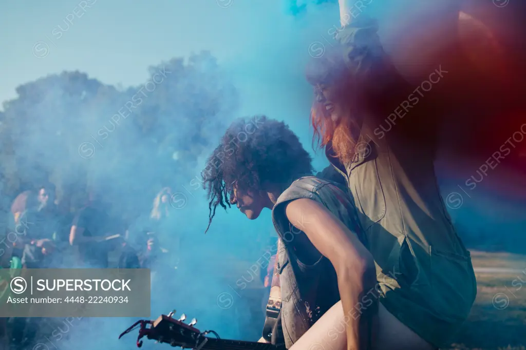 Man piggyback amidst blue powder paint while celebrating Holi