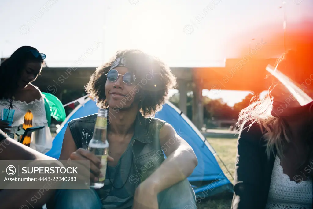 Man drinking alcohol while sitting with friends during event