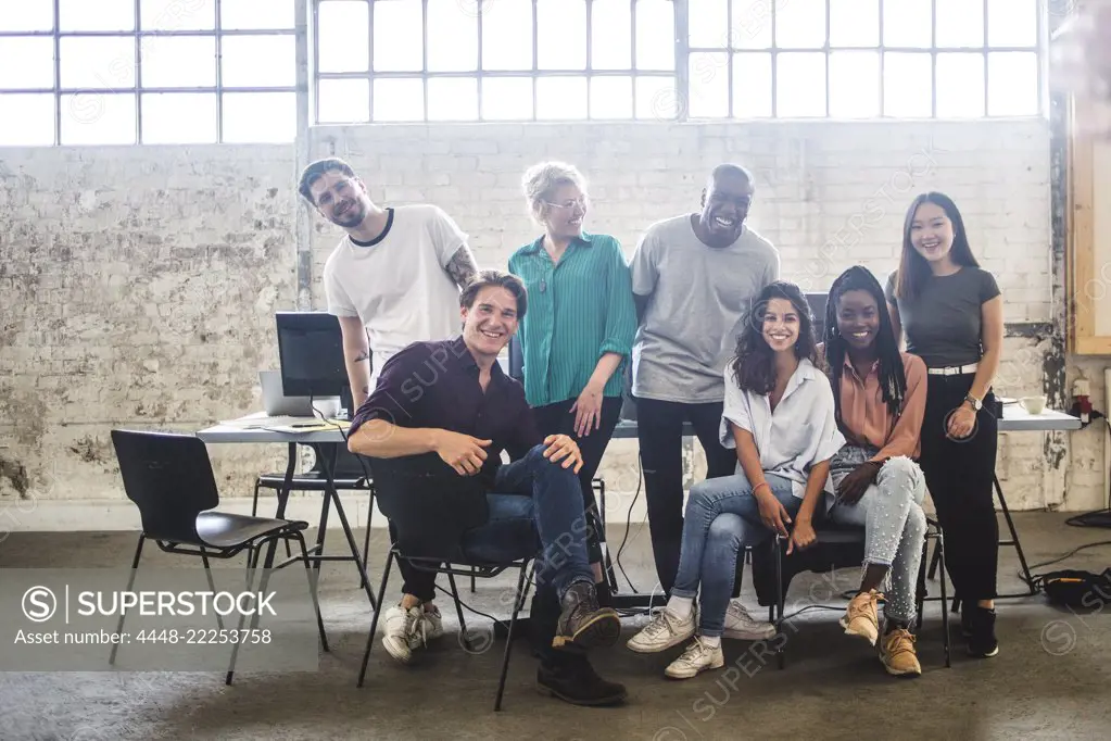 Portrait of cheerful young hacker's team at creative office