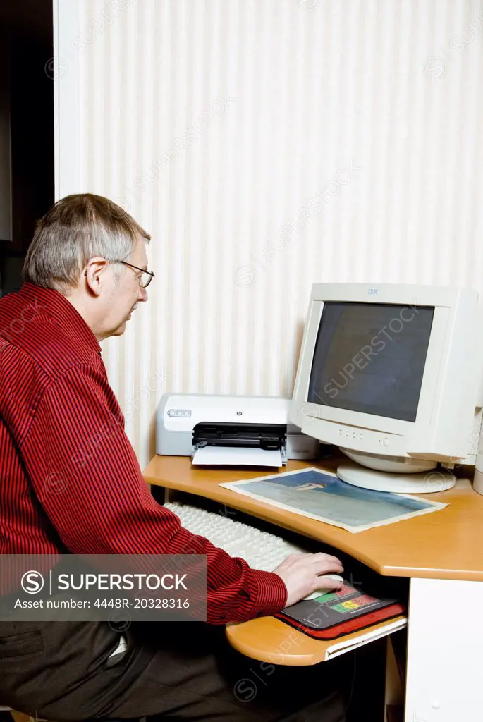 Older man sitting by computer