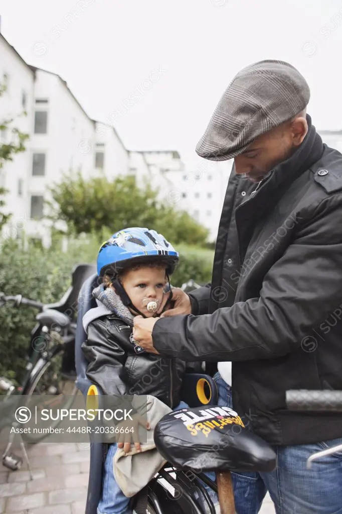 Man helsping son with helmet