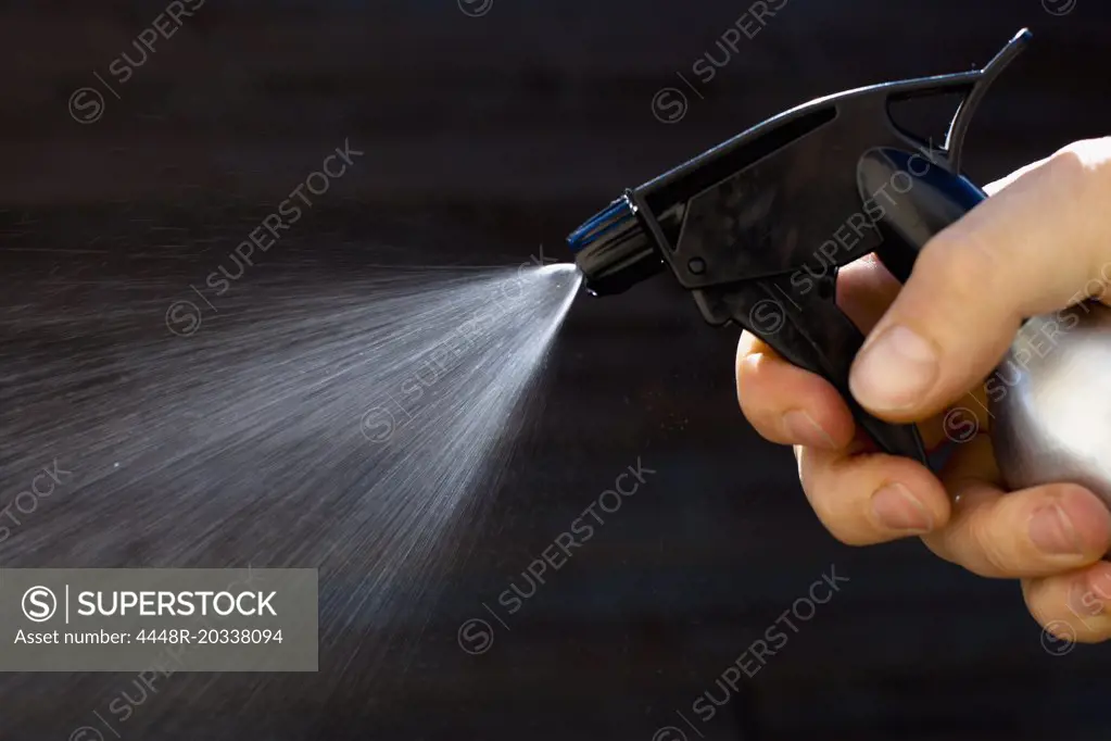 Close-up of men spraying spray bottle