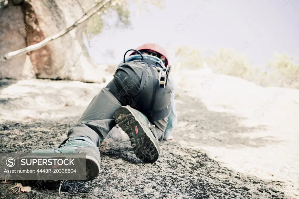 Low section of boy rock climbing