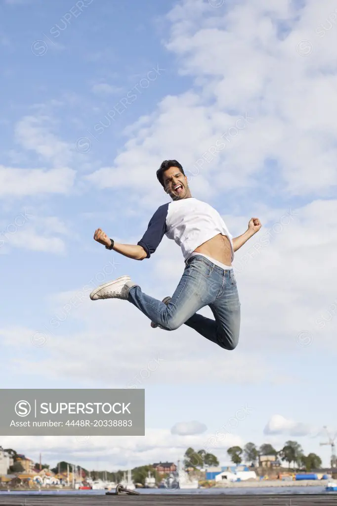 Excited young man jumping in air