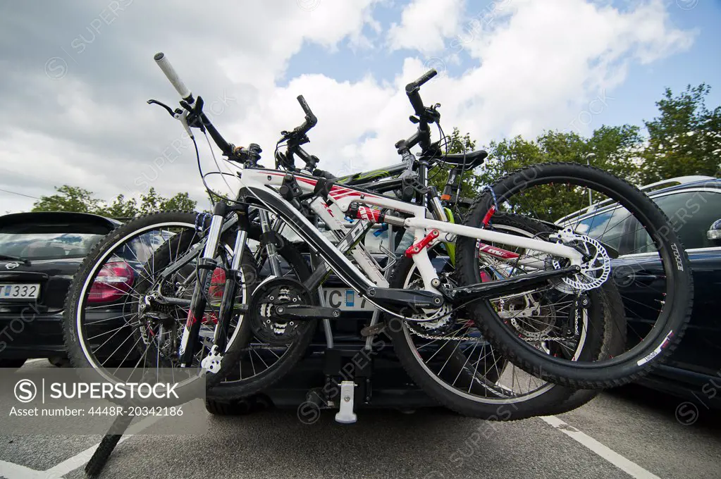 Bicycles locked to car at parking lot