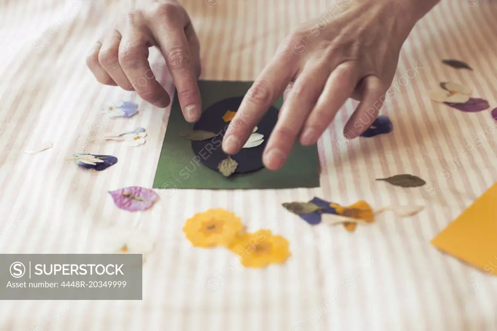 Cropped image of woman making paper craft product on table