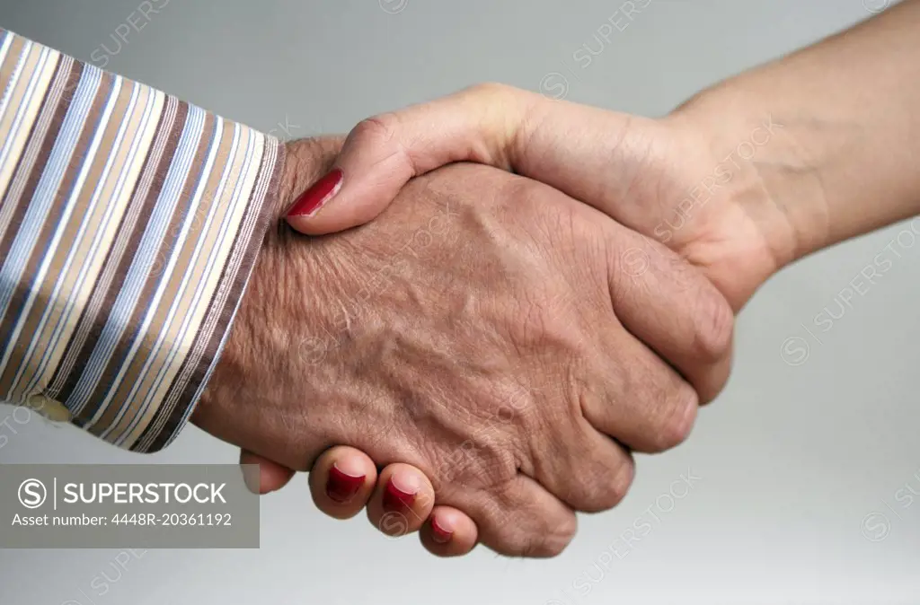 Elderly man and younger woman shaking hands