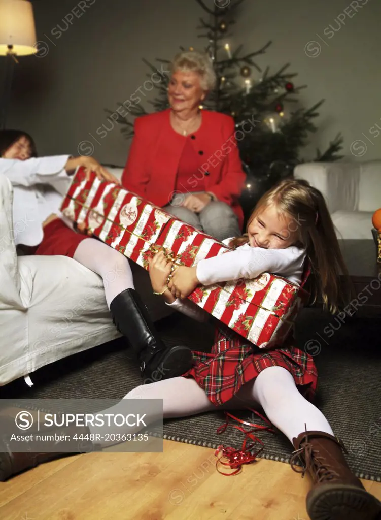 Siblings tearing a Christmas gift