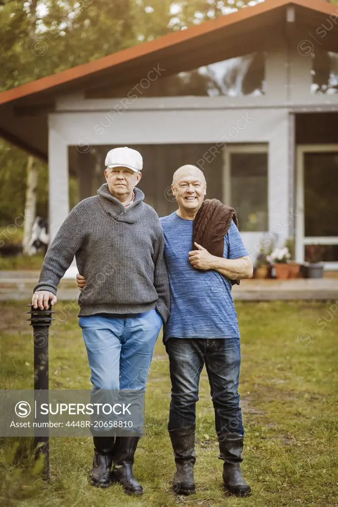 Portrait of happy gay couple standing at yard