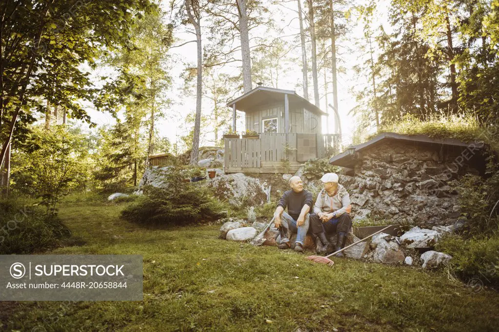 Gay couple sitting on rocks at field