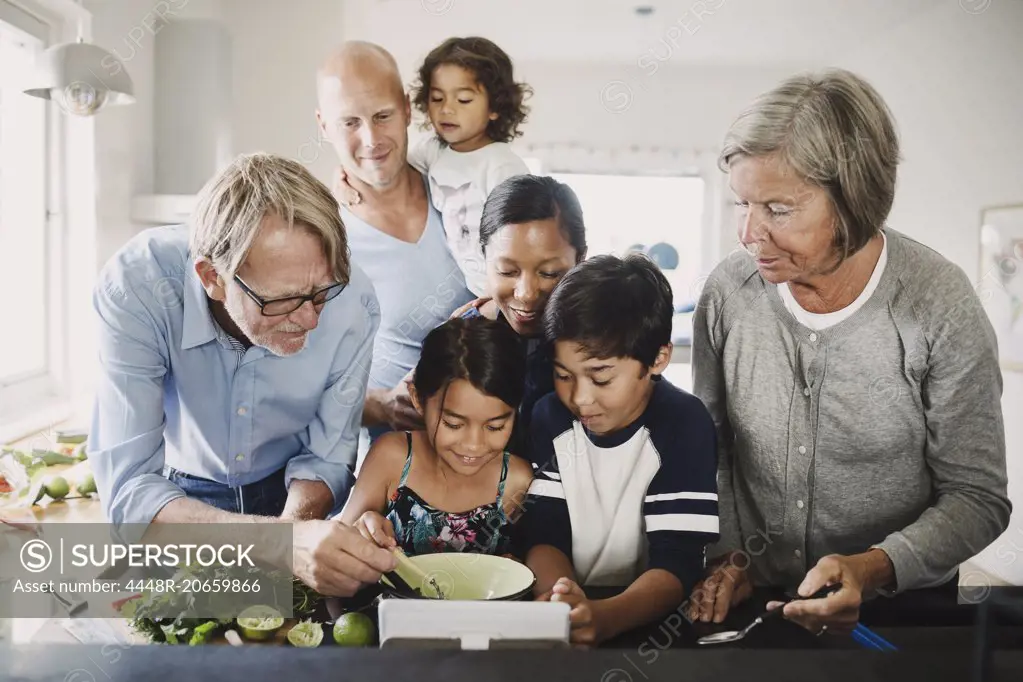 Multi-ethnic family preparing food at kitchen counter