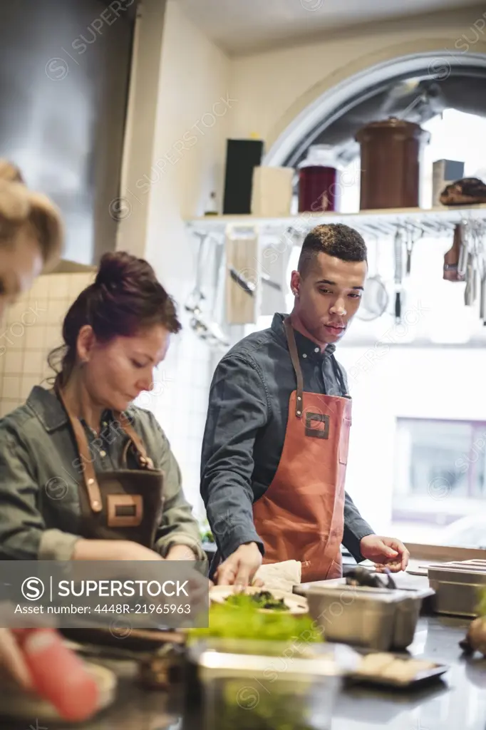 Multi-ethnic chefs cooking food at kitchen counter in restaurant