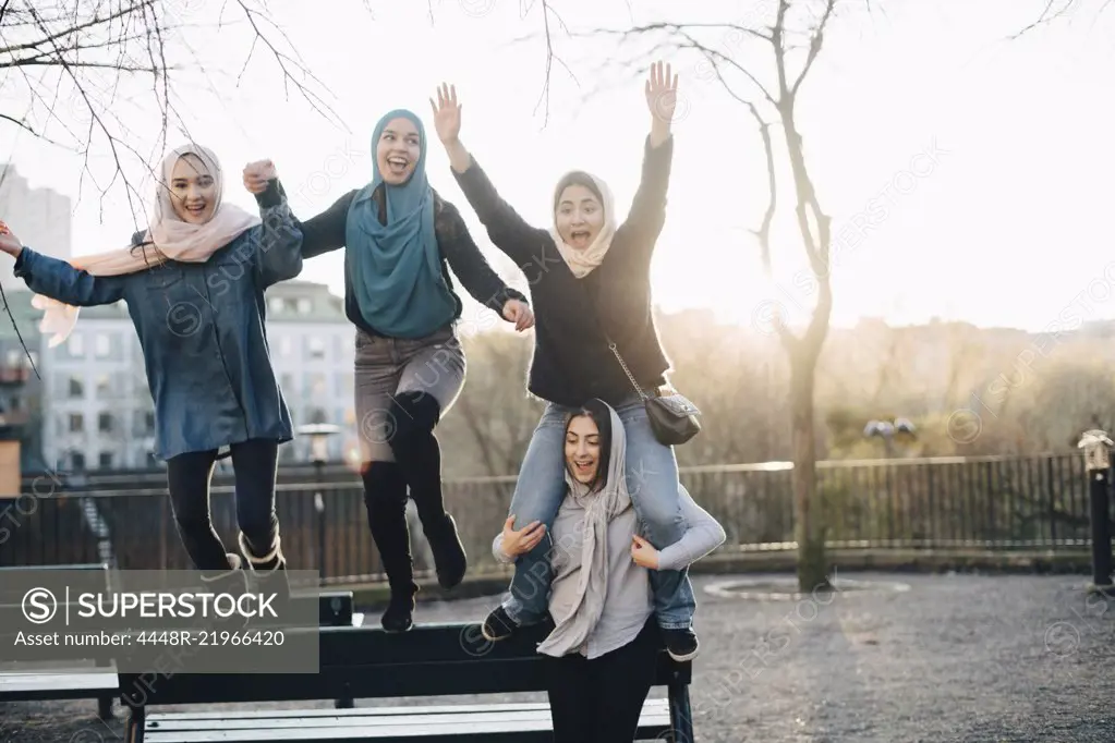 Cheerful multi-ethnic female friends enjoying against clear sky