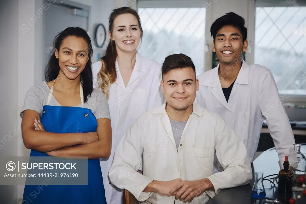 Portrait of confident young multi-ethnic engineering students in chemistry laboratory at university