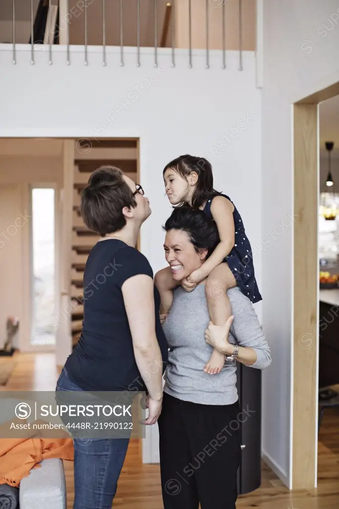 Smiling family enjoying while standing in living room at home