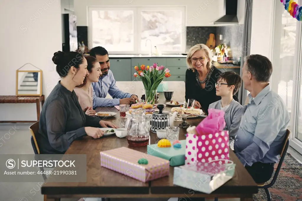 Happy multi-generation family enjoying at table during birthday party