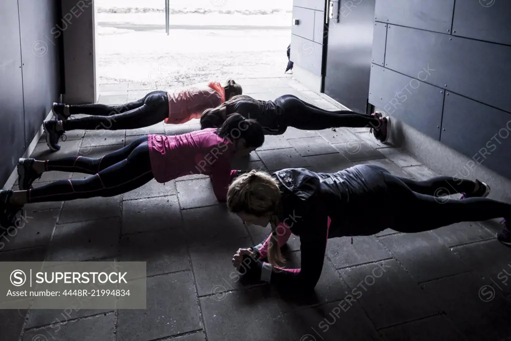 High angle view of women doing plank exercise on footpath during winter