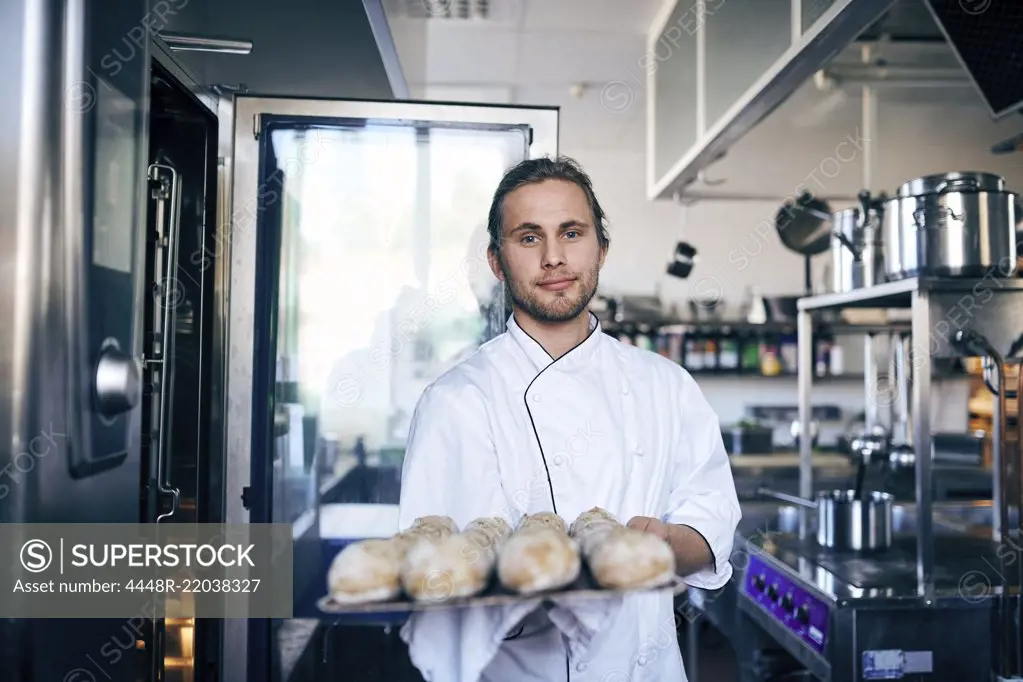 Portrait of chef baking breads in commercial kitchen