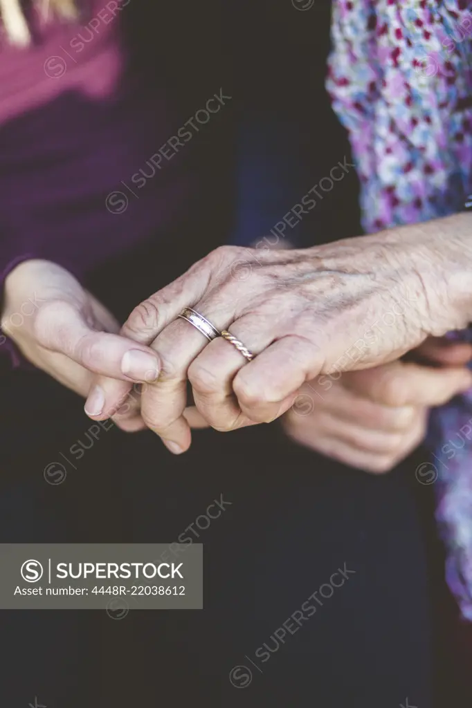 Cropped image of grandmother and granddaughter holding hands