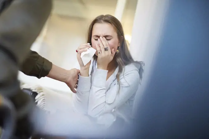 Female doctor consoling sad patient at therapy office