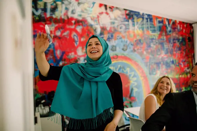 Smiling businesswoman wearing hijab in meeting at convention center