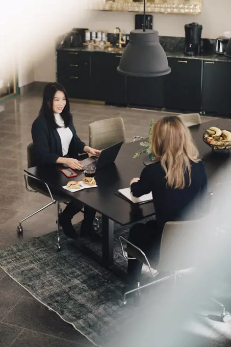 High angle view of female professionals working together at conference table