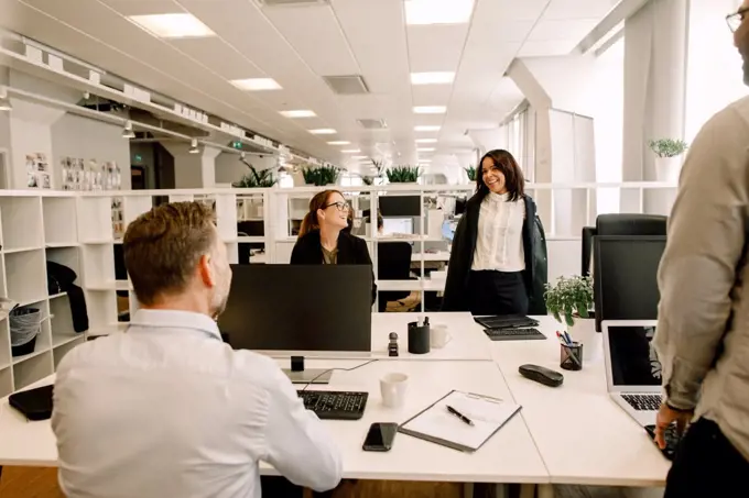 Smiling colleagues working at desk in office