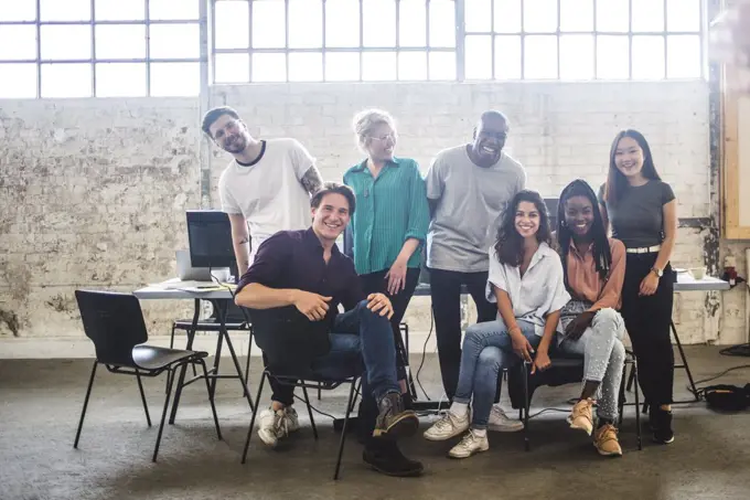 Portrait of cheerful young hacker's team at creative office