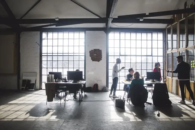 Young businessman giving presentation to programmers during meeting in office