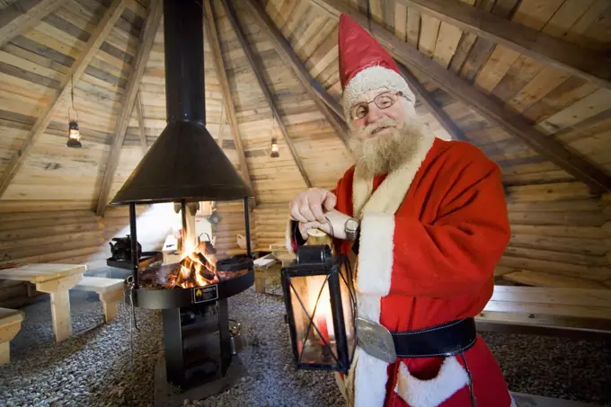 Santa Claus holding lamp in cot