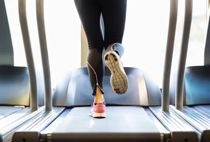 Low section of woman exercising on treadmill