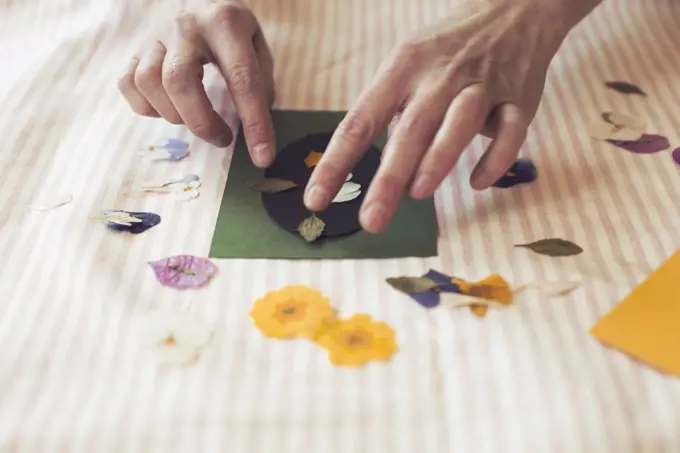 Cropped image of woman making paper craft product on table