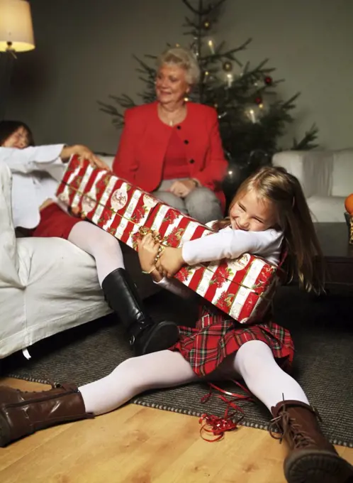 Siblings tearing a Christmas gift